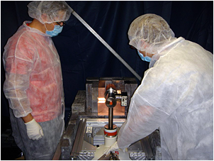 KICP physicist Juan Collar (left) and University of Washington graduate student Mike Marino inspect the CoGeNT experiment at the Soudan Mine in Minnesota. CoGeNT has detected a seasonal signal variation during its first year of operation. This is what scientists would expect if dark matter is made of Weakly Interacting Massive Particles (WIMPs), but the CoGeNT collaboration considers the results to be inconclusive.  <i>Image Credit: Courtesy of CoGeNT Collaboration</i>