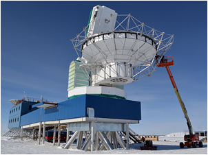 Construction workers on a lift assemble the metal superstructure for the ground shield on the South Pole Telescope during the 2011-12 field season. The shield will eliminate ground reflection inteference as the telescope begins a new experiment on cosmic inflation.   Photo Credit: Peter Rejcek
